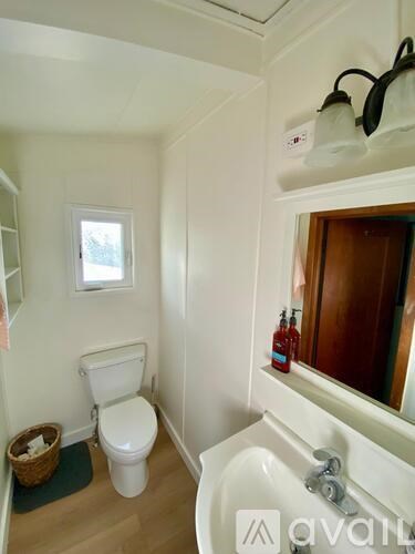 A small white toilet sits in a small bathroom.