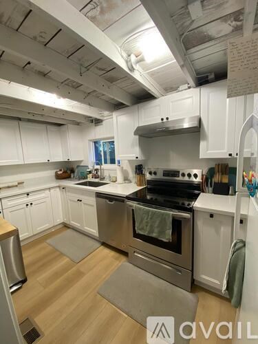 A kitchen with white cabinets and a stainless steel oven.