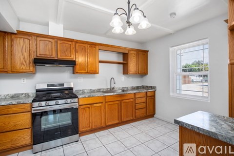 A kitchen with wooden cabinets and a black stove top oven.