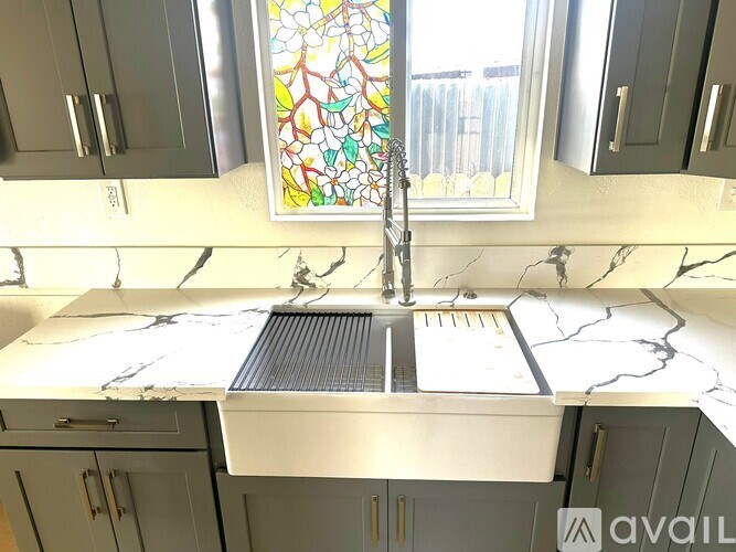 A kitchen with a marble countertop and a stained glass window.