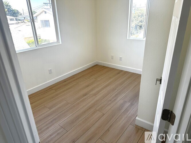 A room with wooden flooring and a window.
