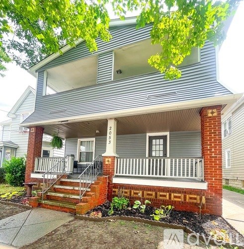 A two-story house with a front porch and a garage door.
