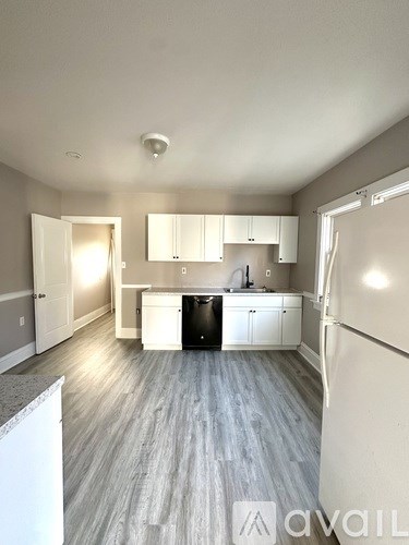 A kitchen with white cabinets and a black dishwasher.