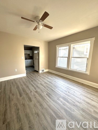 A room with a ceiling fan and a window with blinds.