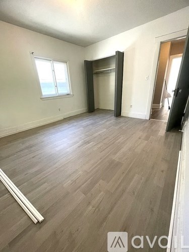 A room with wooden flooring and a window.