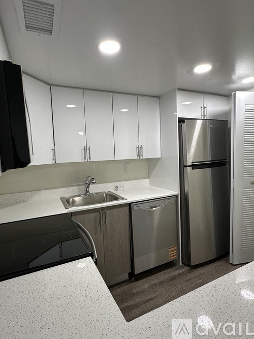 A modern kitchen with stainless steel appliances and white cabinets.