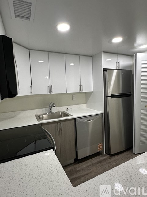 A modern kitchen with stainless steel appliances and white cabinets.