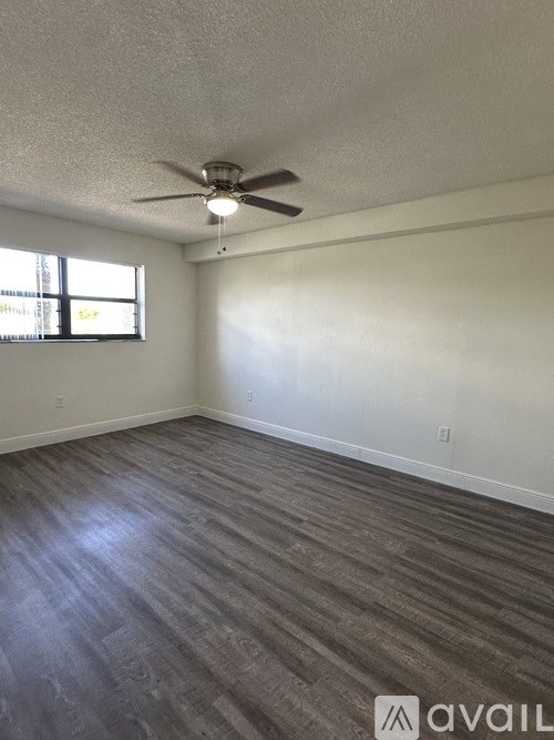 A room with a ceiling fan and a window.