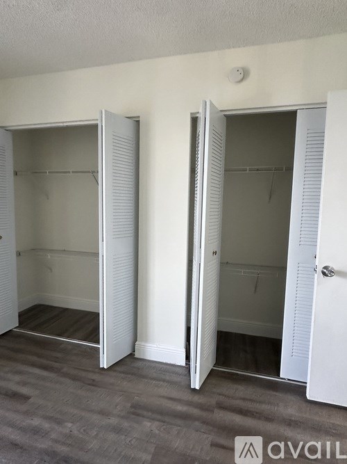 Two white closet doors open to reveal empty shelves.