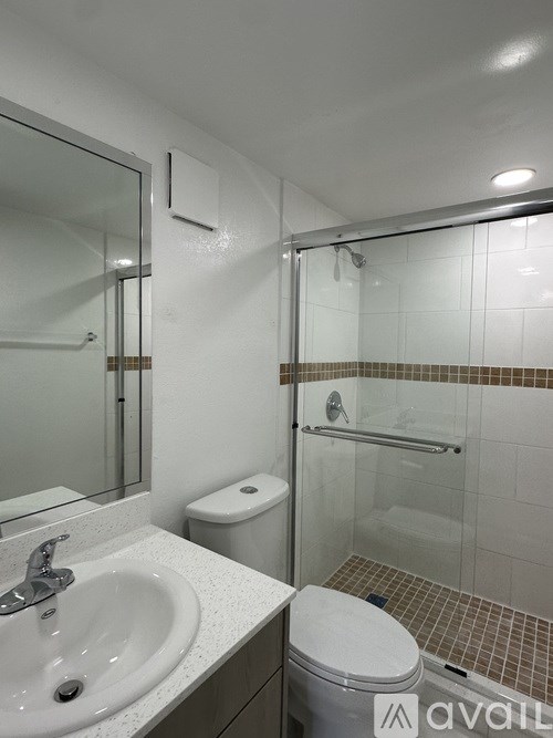 A bathroom with a toilet, sink, and shower.