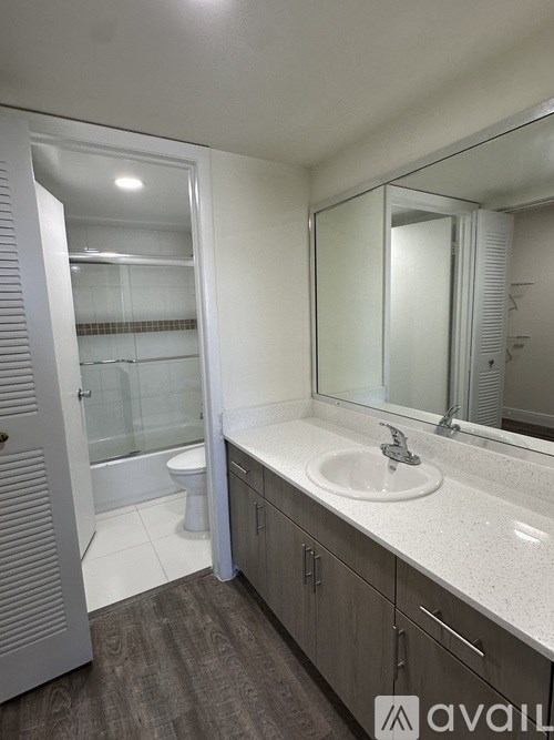 A bathroom with a sink, mirror, and a toilet.