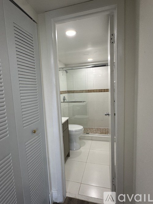 A white bathroom with a toilet and a shower.