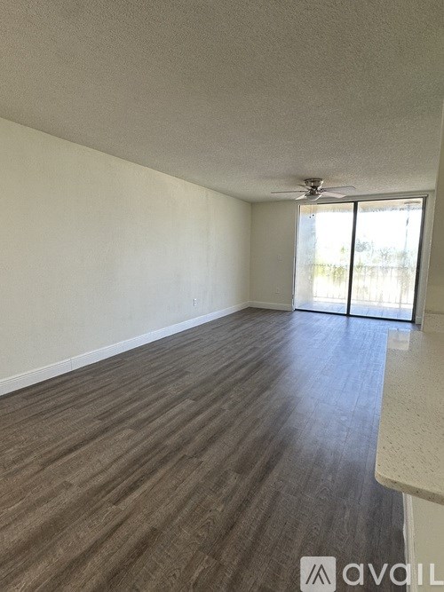 A room with wooden flooring and a sliding glass door.
