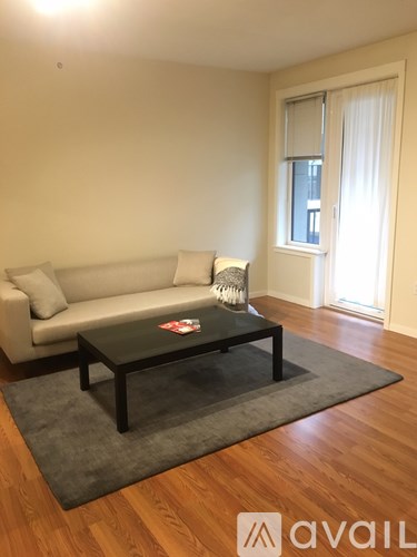 A living room with a couch, a coffee table, and a rug.