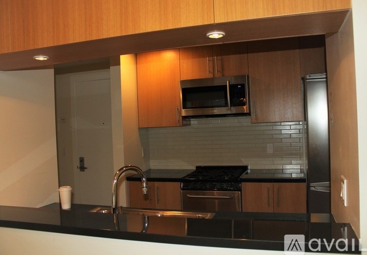 A kitchen with wooden cabinets and a black countertop.