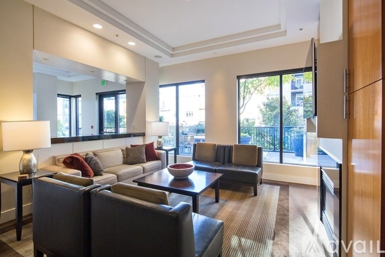 A living room with a couch, chairs, and a table with a lamp on it.