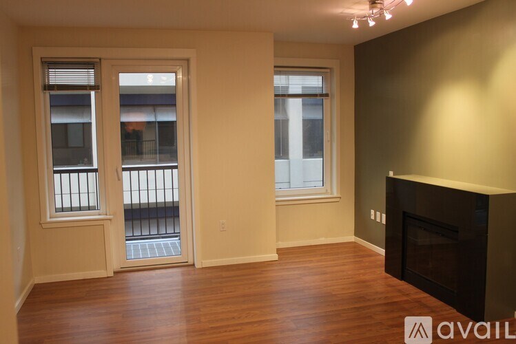 A living room with a fireplace and two windows.