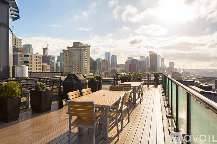 A wooden deck with a table and chairs overlooking a city skyline.