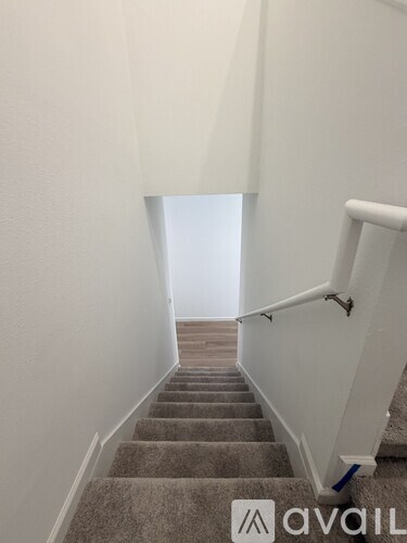 A staircase with a carpeted runner and white walls.