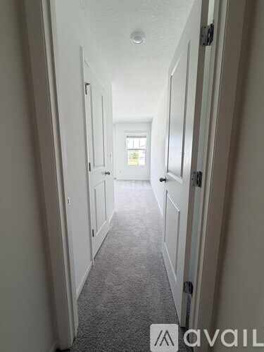 A long hallway with white doors on both sides.