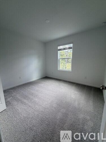 A room with a window and carpeted floor.