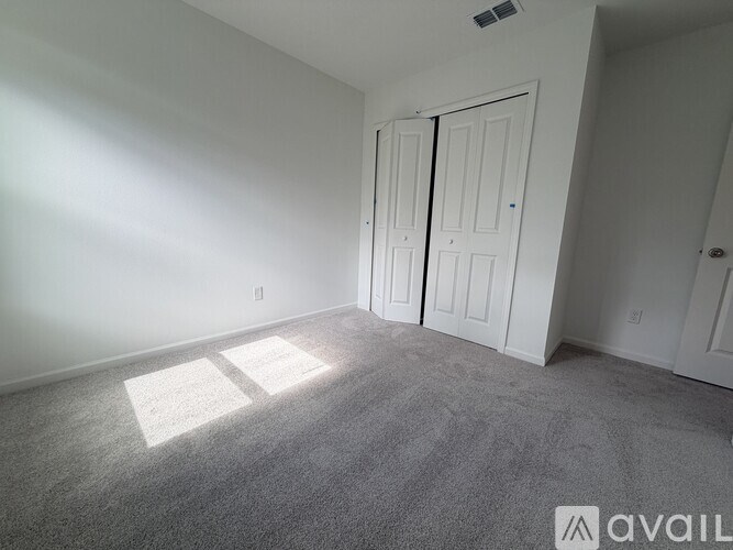 A room with two doors and carpeted floor.