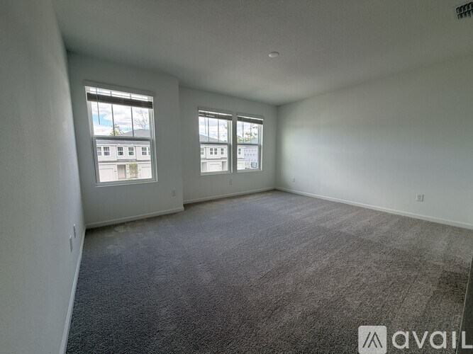 A long hallway with white doors and wooden floors.