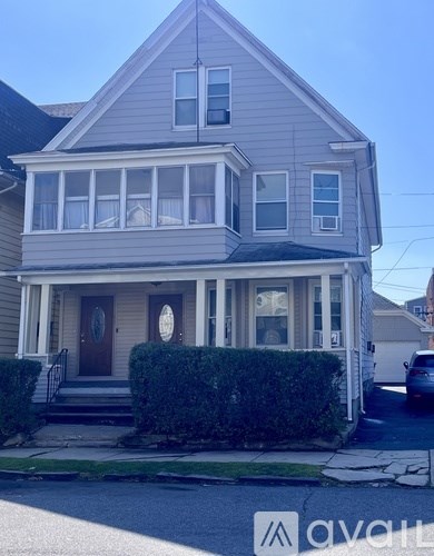 A two-story house with a grey facade and a brown door.