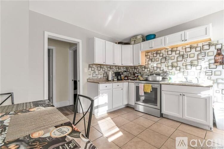 A kitchen with white cabinets and a tile backsplash.