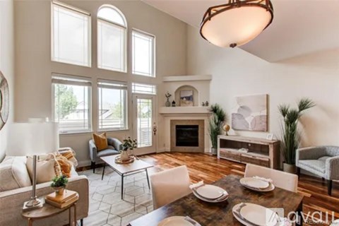 A living room with a fireplace and a dining table set for a meal.