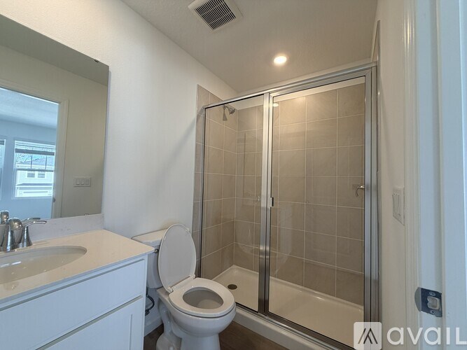 A bathroom with a toilet, sink, and shower.