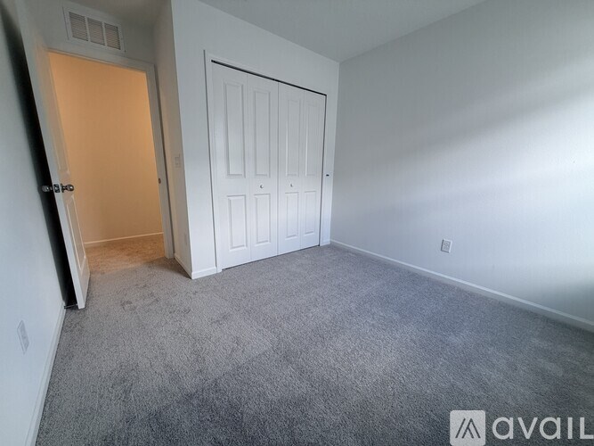A room with a carpeted floor and a white door.