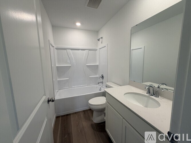 A white bathroom with a toilet, sink, and bathtub.