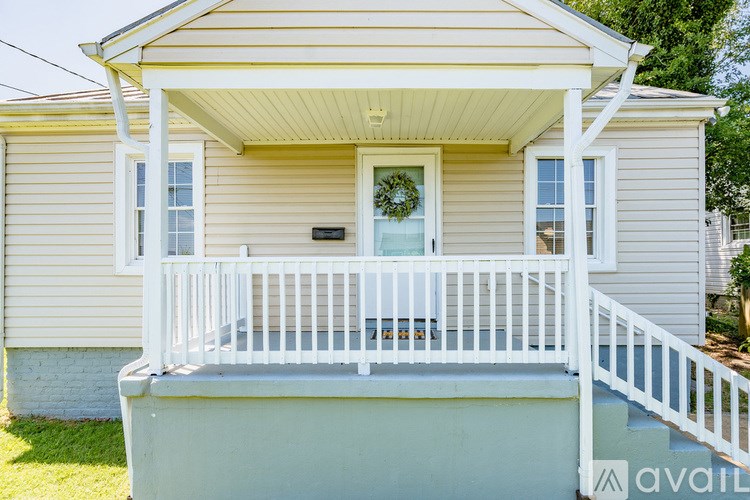 A small house with a porch and a wreath on the door.