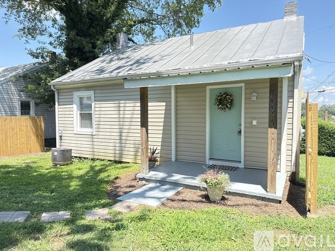 A small house with a green door and a wreath on it.