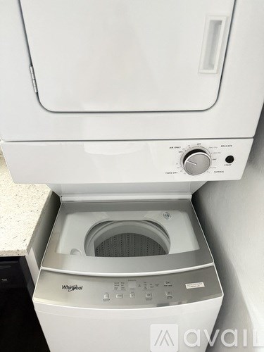 A white Whirlpool washing machine with the door open.
