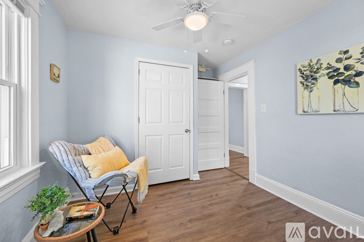 A room with a ceiling fan and a painting on the wall.