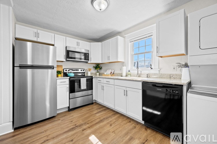 A living room with a white chair, a wooden table, and a plant on it.