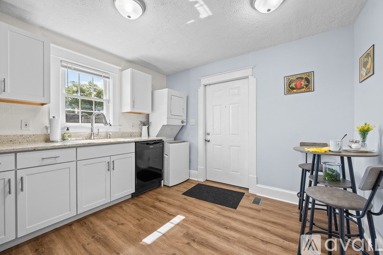 A white toilet sits next to a white sink in a small bathroom.