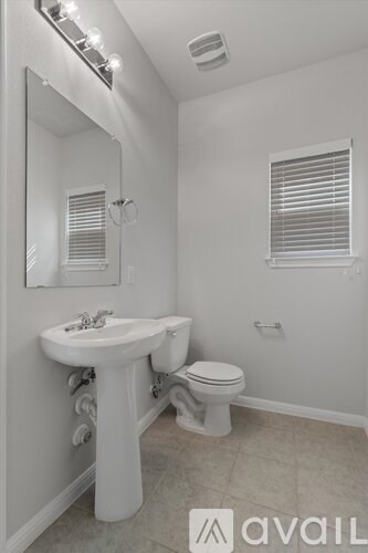 A bathroom with a sink, toilet and mirror.