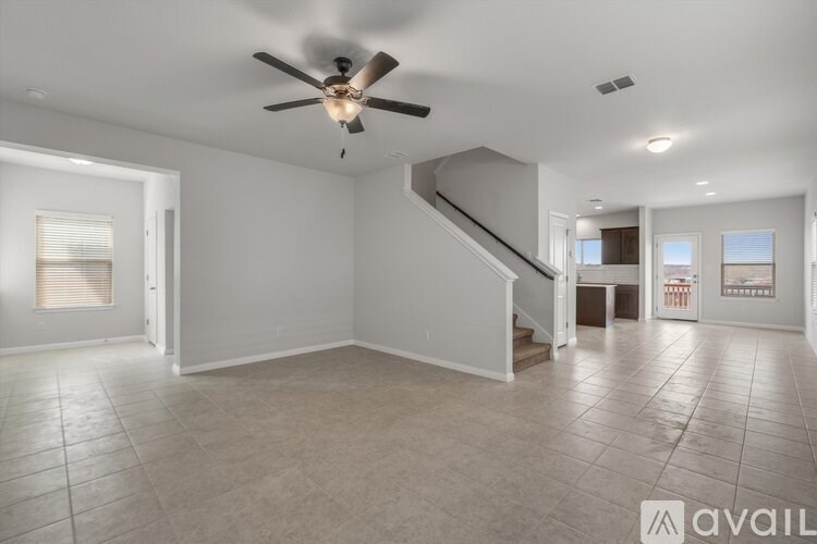 A spacious room with a ceiling fan and tiled flooring.