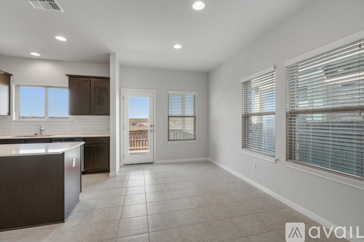 A spacious kitchen with brown cabinets and a tiled floor.