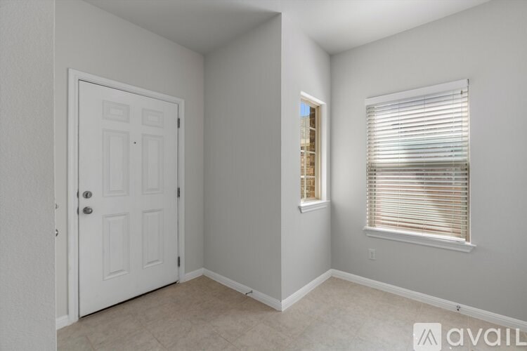 A room with a white door and a window with blinds.