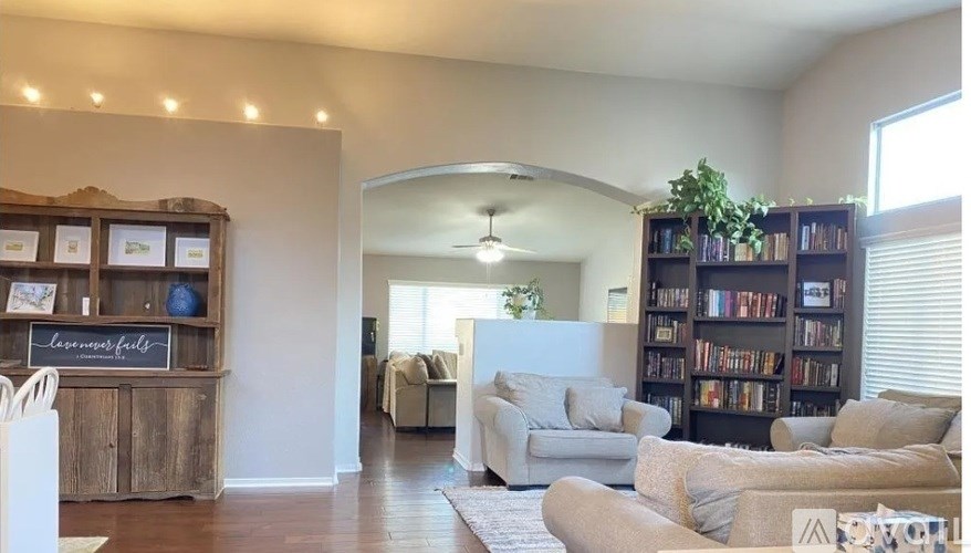 A living room with a couch, a bookshelf, and a rug.