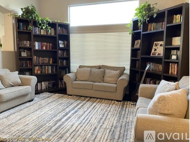 A living room with a couch, chair, and bookshelves.