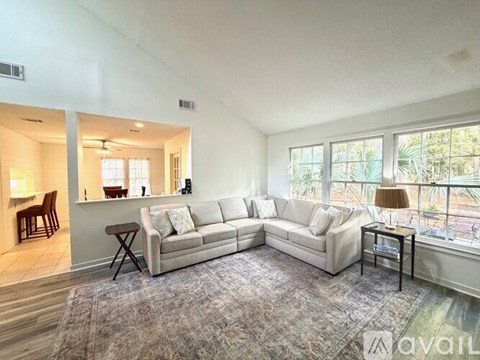 A living room with a white couch and a rug.