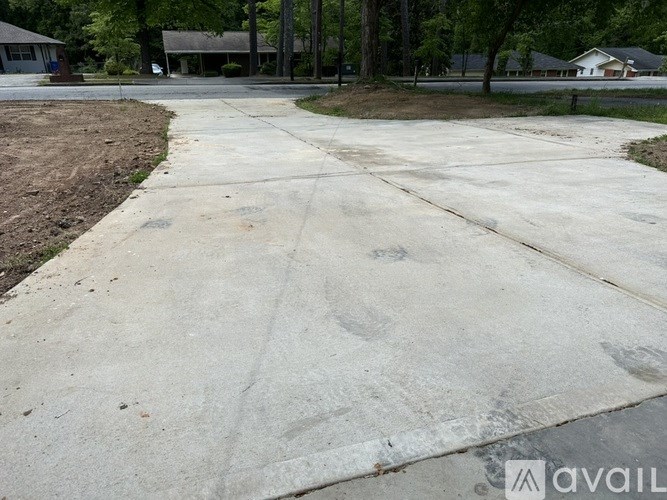 A concrete driveway with a rough surface and a few cracks.