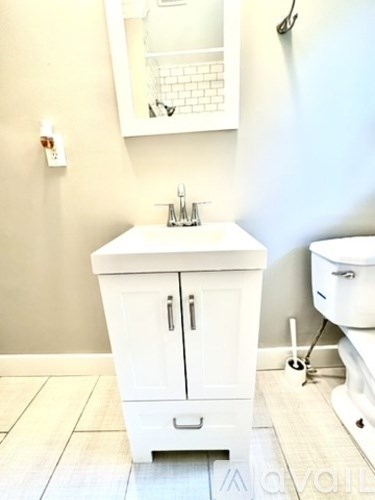 A white bathroom with a sink and a mirror.