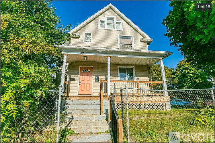 A two-story house with a red door and a balcony.