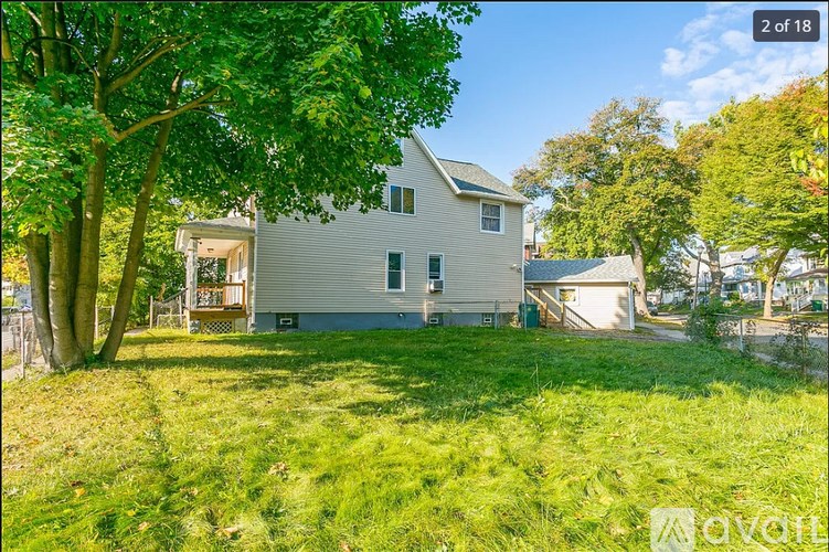A house with a white exterior and a green lawn in front.